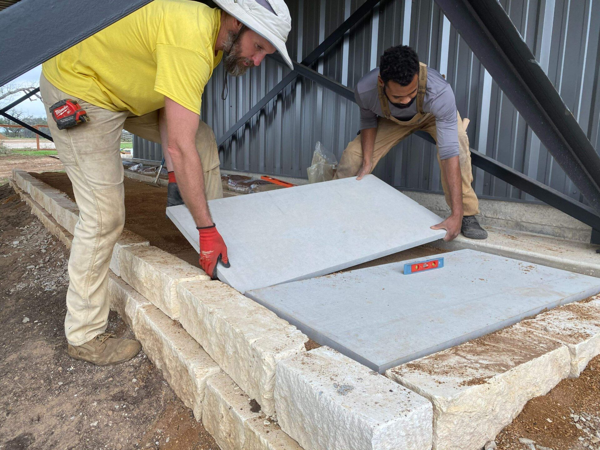 Chris and Adam laying leuder stones for a Permaculture Homestead foundation 