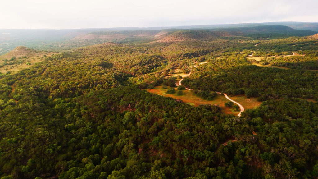 Aerial view of rolling hills and mixed woodland in the Texas Hill Country.