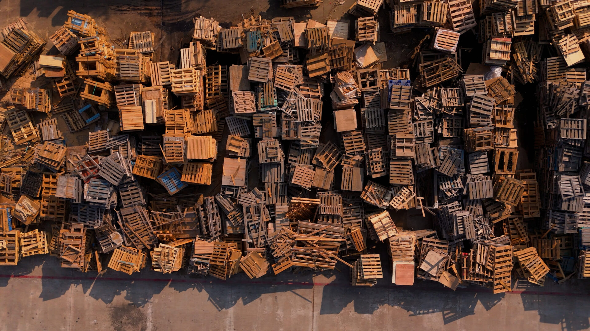 Stacked recycled wooden pallets at Texas recycling facility used for biochar feedstock