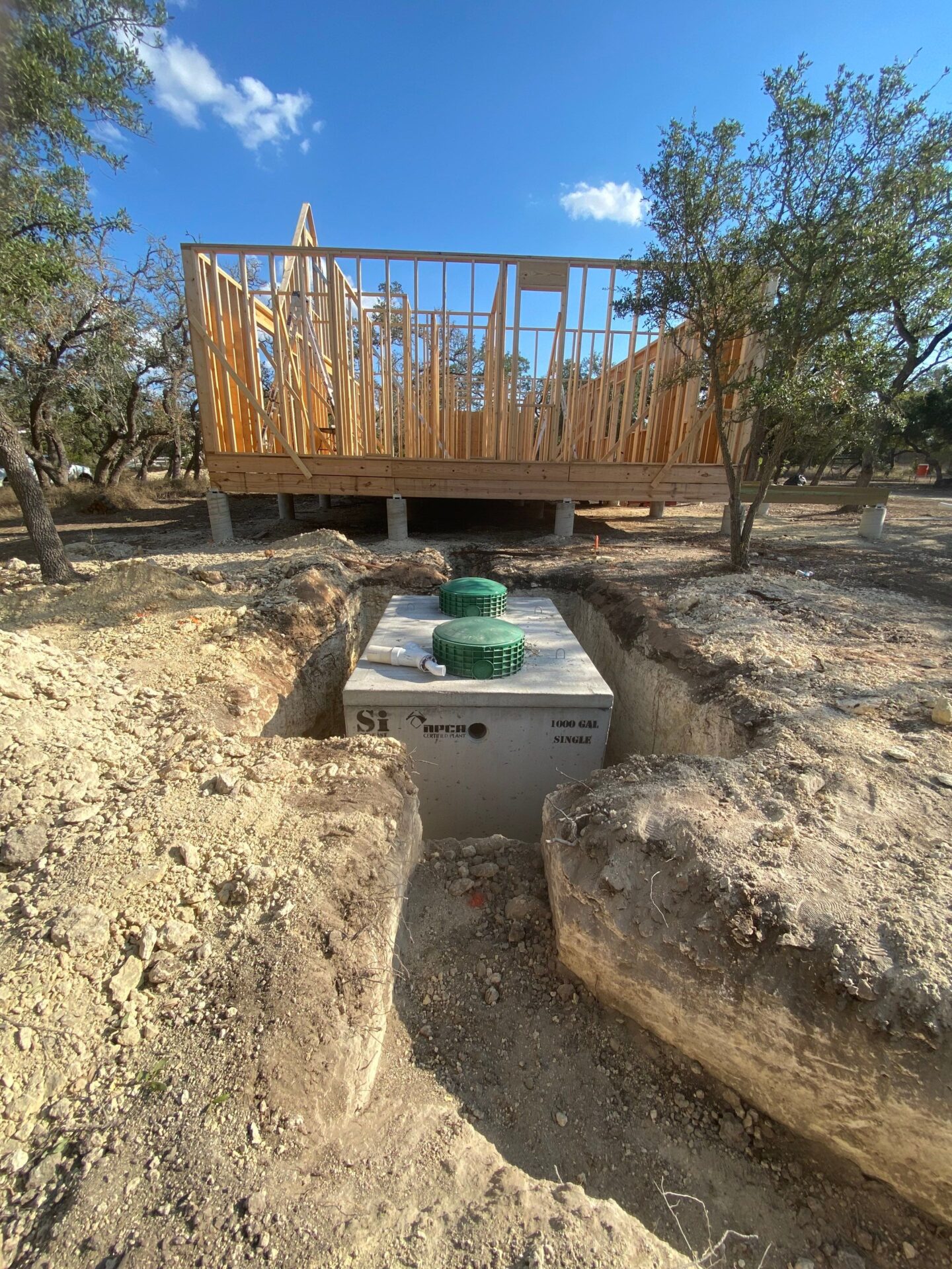 Septic treatment tank being installed during construction, part of a system that reuses household wastewater for irrigation.