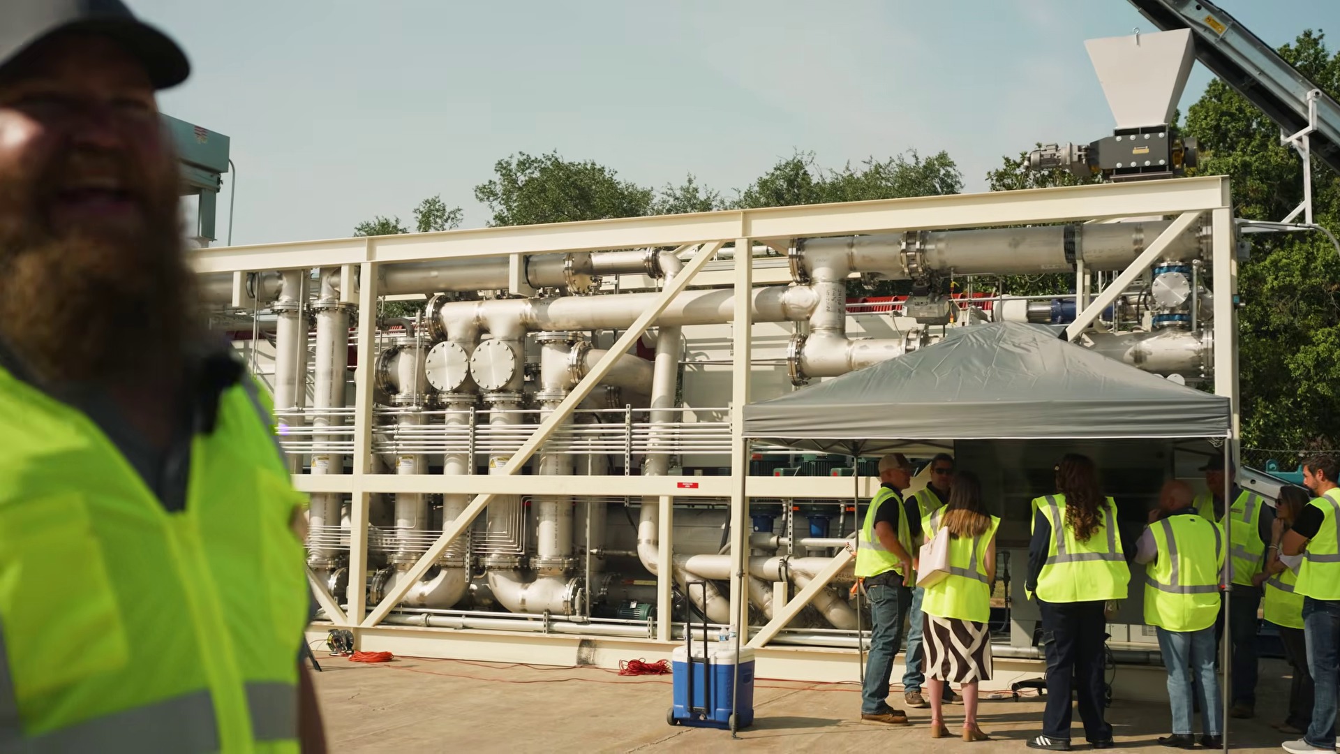 Group in safety vests touring the Rainmaker pyrolysis bioreactor at the LOCOAL facility in Houston