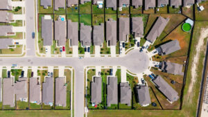 Aerial view of a suburban Austin neighborhood with HOA-governed properties and uniform lawns