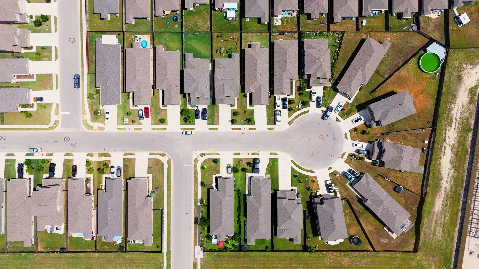 Aerial view of a suburban Austin neighborhood with HOA-governed properties and uniform lawns